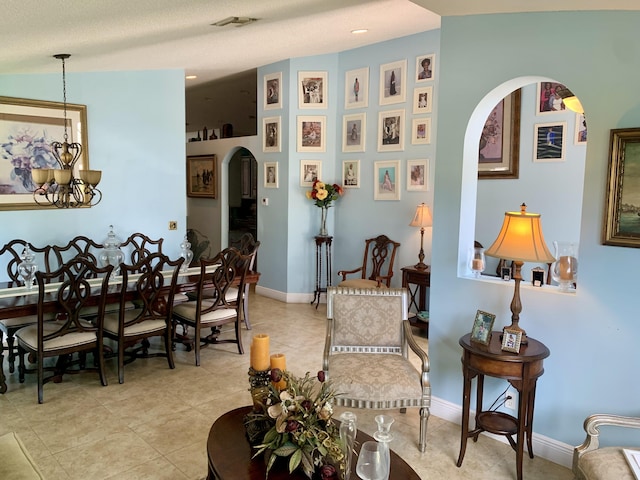 tiled living room with a textured ceiling, vaulted ceiling, and an inviting chandelier