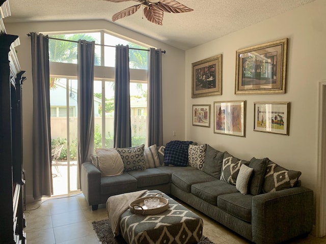 tiled living room with ceiling fan, lofted ceiling, and a textured ceiling