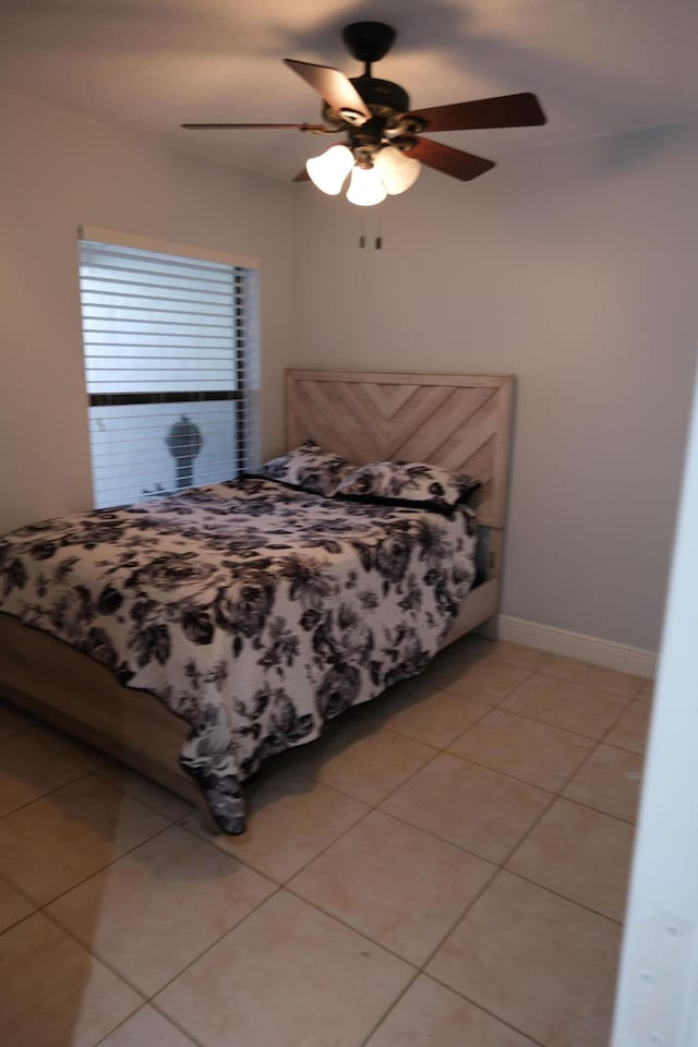 tiled bedroom featuring ceiling fan