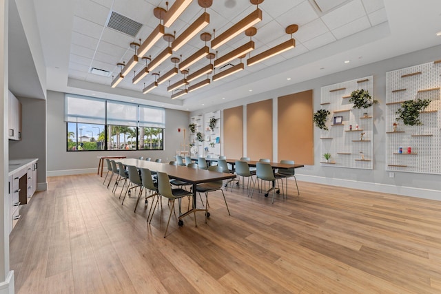 dining room featuring light hardwood / wood-style floors and a tray ceiling