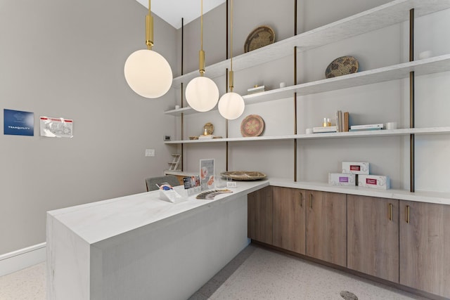 kitchen with light speckled floor, light countertops, decorative light fixtures, and open shelves