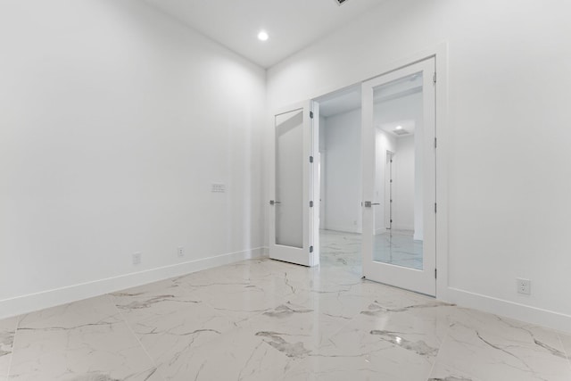 spare room with marble finish floor, french doors, recessed lighting, and baseboards