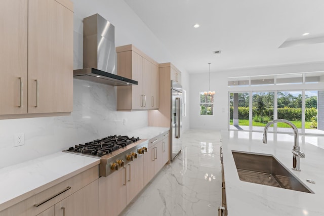 kitchen featuring appliances with stainless steel finishes, light brown cabinets, plenty of natural light, and wall chimney range hood