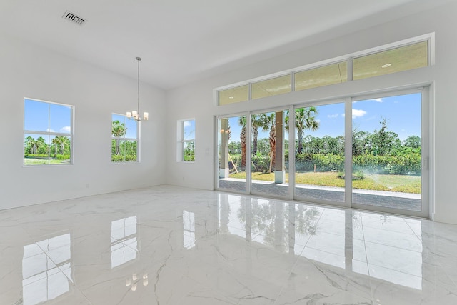 spare room with a chandelier, marble finish floor, and visible vents