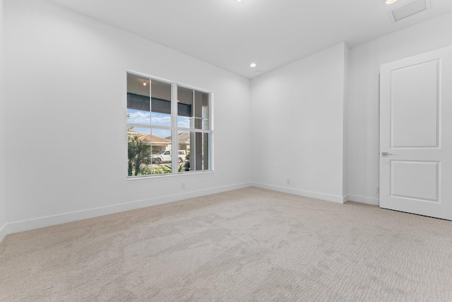 unfurnished room with recessed lighting, light carpet, visible vents, and baseboards