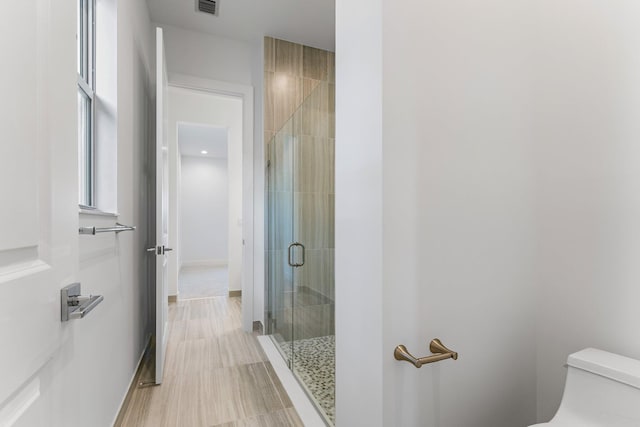 full bath featuring toilet, a stall shower, and visible vents