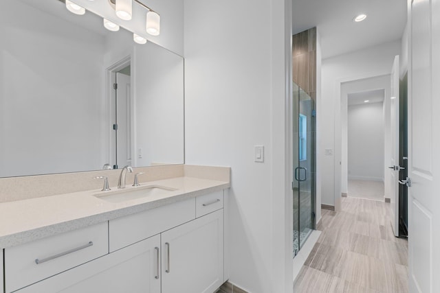 bathroom featuring a shower with shower door, vanity, and tile patterned flooring