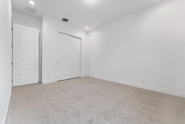 empty room with baseboards, recessed lighting, visible vents, and light colored carpet