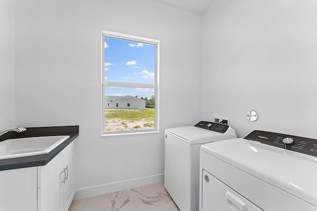 laundry area featuring washer and clothes dryer, sink, a wealth of natural light, and light tile patterned floors