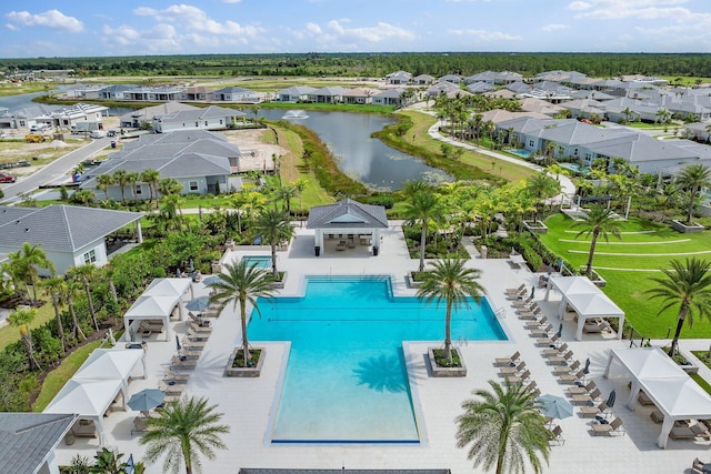 community pool with a water view, a residential view, and a patio