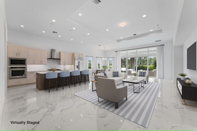 tiled living room with sink and a raised ceiling