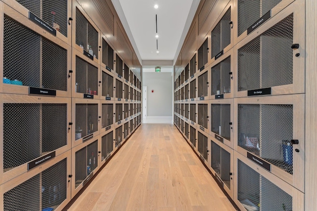 wine area with light wood-type flooring and baseboards