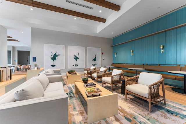 living area with recessed lighting, visible vents, beamed ceiling, and light wood-style flooring