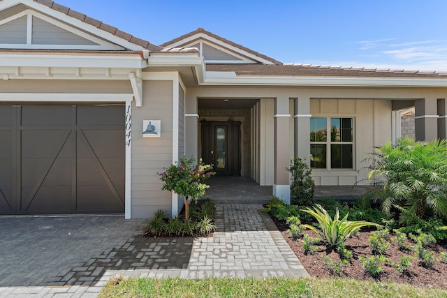 entrance to property featuring a garage and a tiled roof