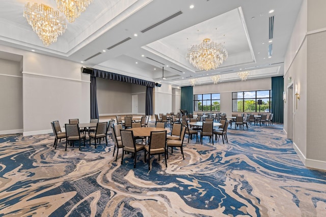 dining space featuring carpet floors, a tray ceiling, a notable chandelier, visible vents, and baseboards