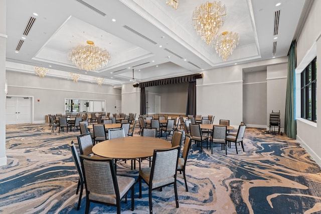 carpeted dining area with a chandelier and a tray ceiling