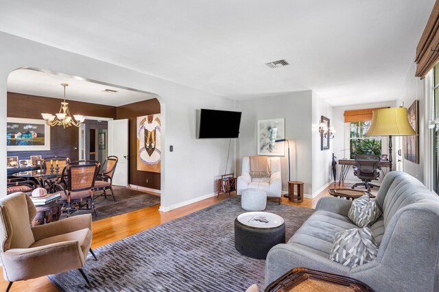 living room featuring a chandelier and wood-type flooring