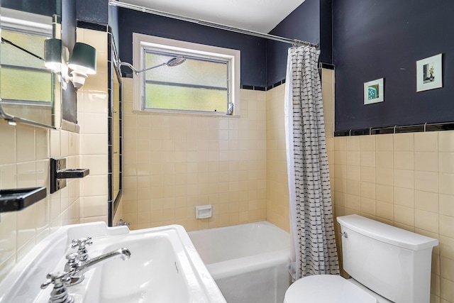 full bathroom with tile walls, sink, toilet, and shower / bath combo with shower curtain