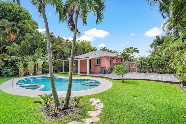 view of swimming pool featuring a deck and a lawn