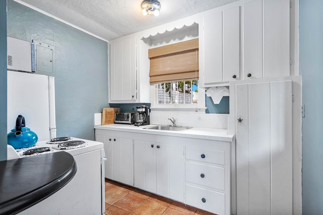 kitchen featuring light tile floors, white cabinetry, and range