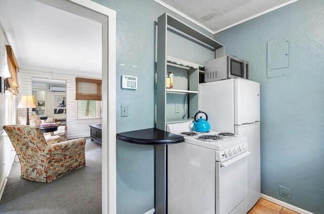 kitchen featuring white appliances, a wall unit AC, and crown molding