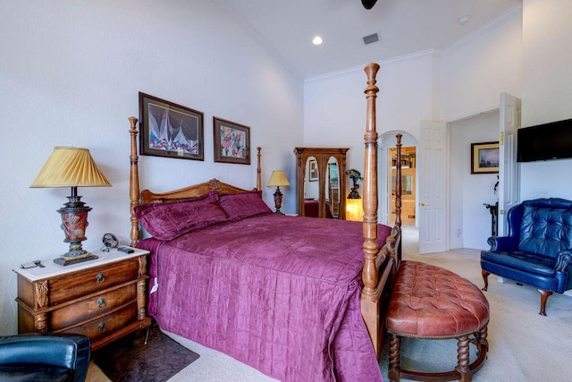 bedroom with a towering ceiling, ornamental molding, and light carpet