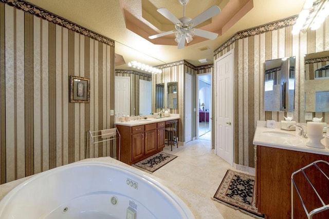 bathroom featuring ceiling fan, a tub to relax in, and vanity