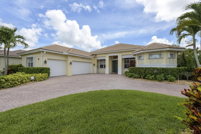 view of front of property with a front yard and a garage