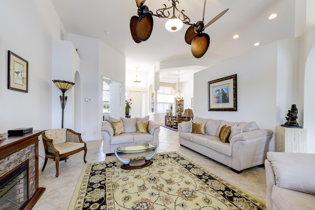 tiled living room featuring a fireplace and a chandelier