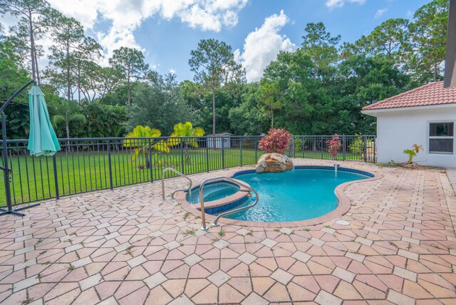 view of swimming pool featuring a patio area, a lawn, an in ground hot tub, and pool water feature