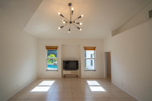 unfurnished living room with light tile flooring, plenty of natural light, and a chandelier