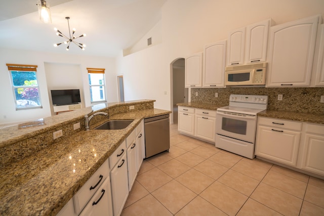 kitchen with sink, vaulted ceiling, white appliances, and backsplash