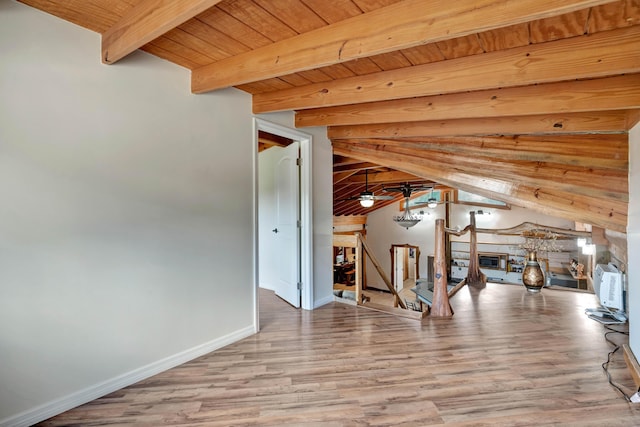 interior space featuring ceiling fan, hardwood / wood-style floors, beam ceiling, wooden ceiling, and wood walls