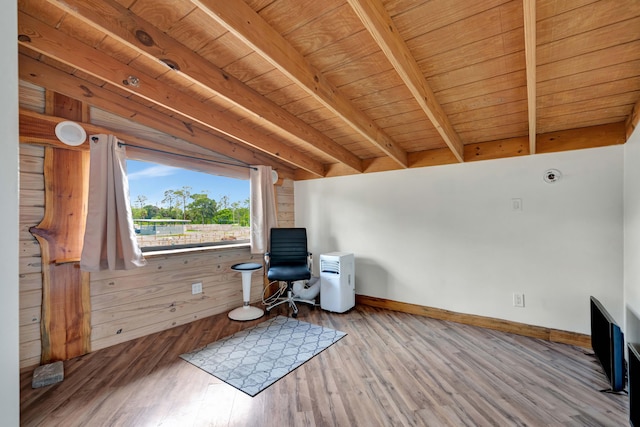 unfurnished room featuring hardwood / wood-style floors, wooden walls, wooden ceiling, and beamed ceiling