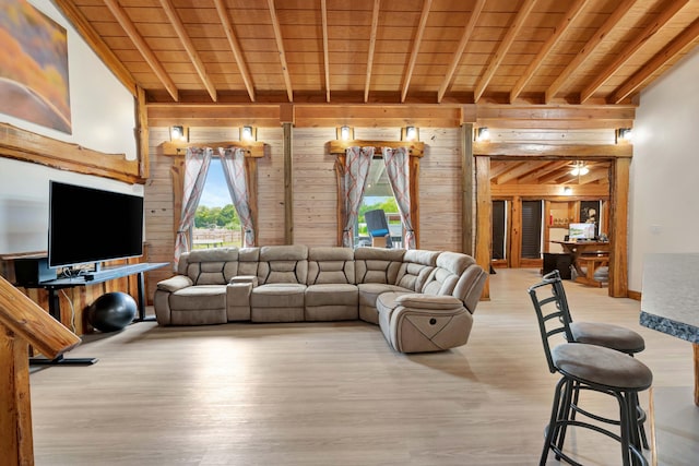 living room featuring wood walls, light hardwood / wood-style floors, lofted ceiling with beams, and wooden ceiling