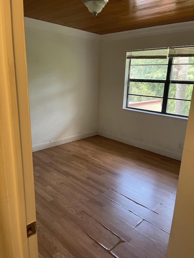 unfurnished room featuring ornamental molding, wooden ceiling, and light hardwood / wood-style floors