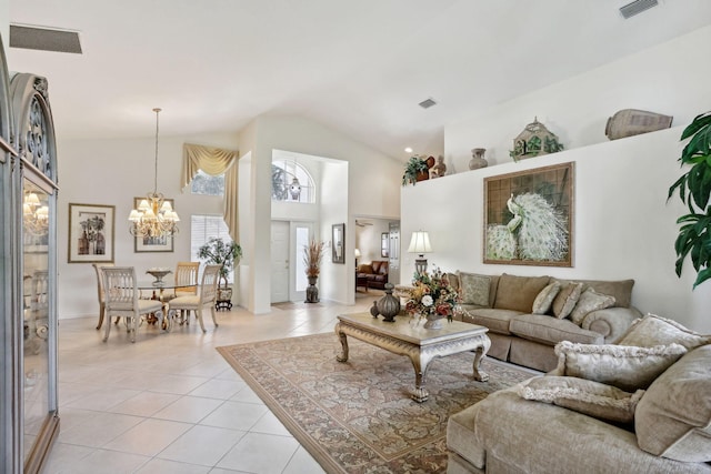 living room with light tile patterned floors, high vaulted ceiling, and an inviting chandelier