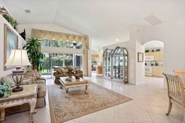 living room with light tile patterned flooring and vaulted ceiling