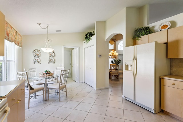 tiled dining room featuring lofted ceiling