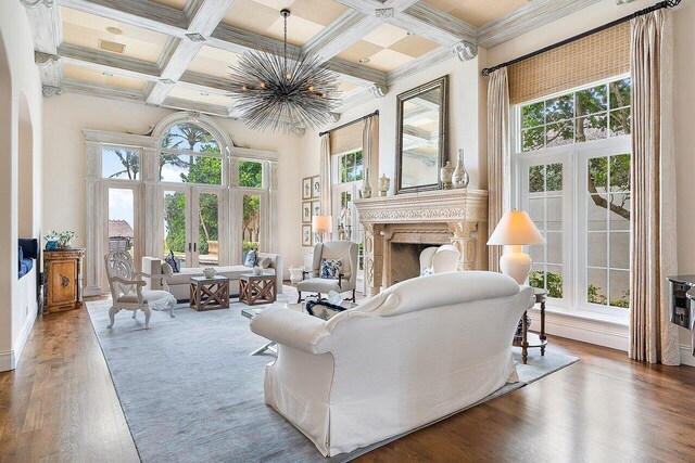 living room with hardwood / wood-style floors, french doors, a high ceiling, beam ceiling, and coffered ceiling