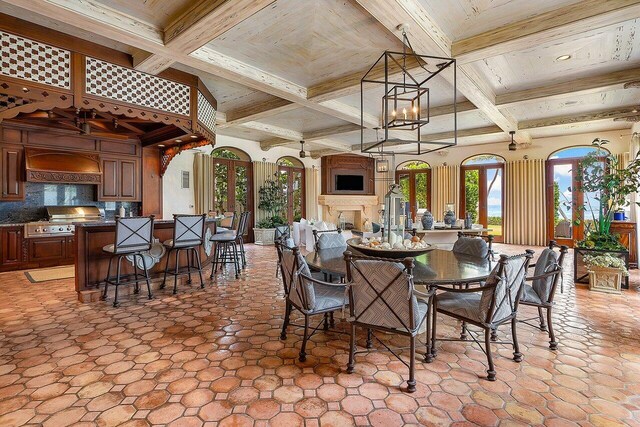 dining area featuring beam ceiling, coffered ceiling, and light tile patterned floors