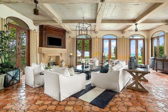 unfurnished living room with tile patterned flooring, beamed ceiling, french doors, and coffered ceiling