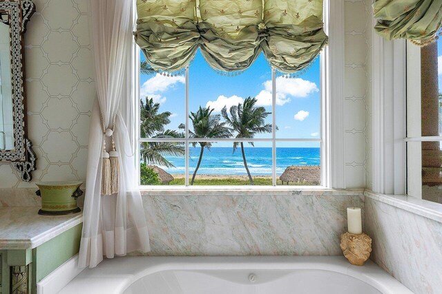 bathroom with a water view and a bath