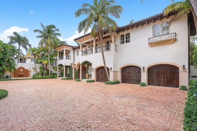 mediterranean / spanish house featuring a garage and a balcony