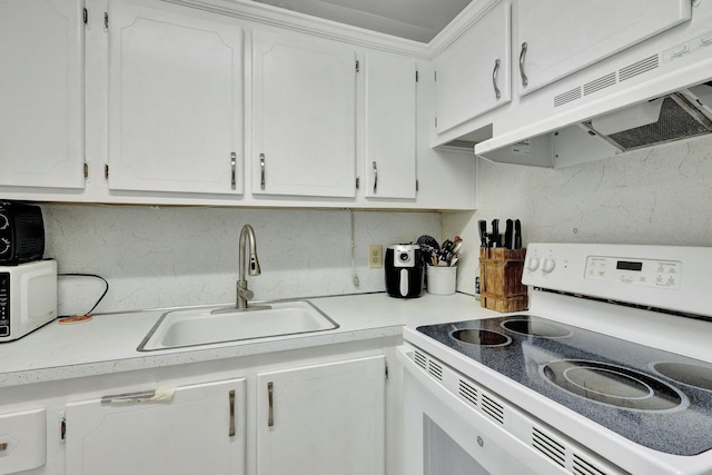 kitchen with sink, white appliances, and white cabinetry