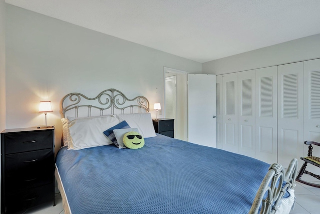 bedroom with a closet and light tile floors