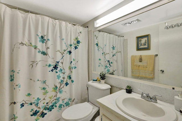 bathroom featuring toilet and vanity with extensive cabinet space