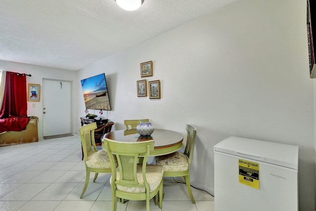 tiled dining area with a textured ceiling