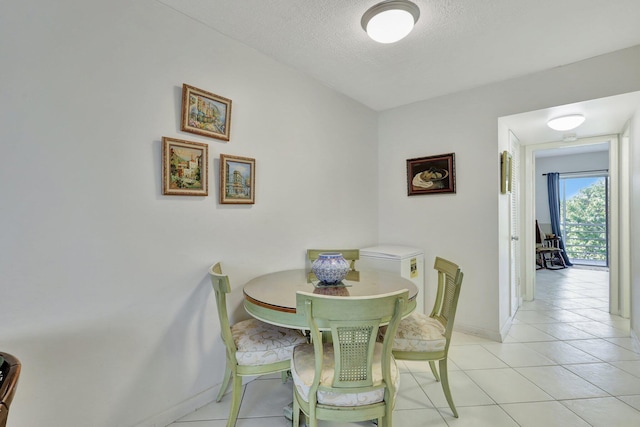 dining room featuring a textured ceiling and light tile floors