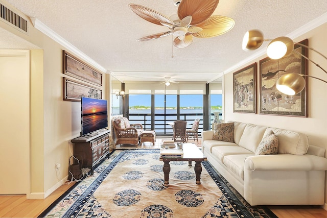 living room featuring hardwood / wood-style floors, a textured ceiling, and crown molding